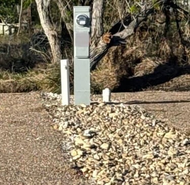 RV Site with meter, water. and clean out in a wooded RV park