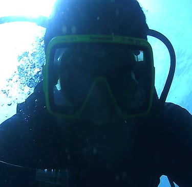 a person wearing a scuba suit and a scuba mask for night dive in lovina reef