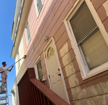 a man is painting a house with a ladder