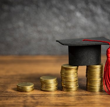 a graduation cap with a graduation cap on top of a stack of coins