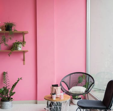 a pink room with a chair and a chair
