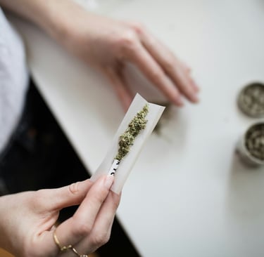 a person holding a piece of paper with a marijuana leaf