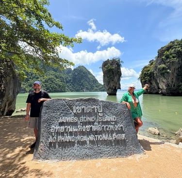 two men standing next to a large rock