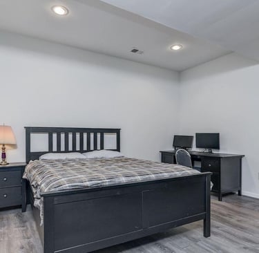 New bedroom with walk-in closet, grey LVT flooring, and recessed lighting.