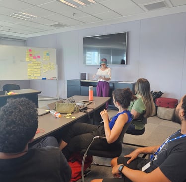 Gabriela Bechara Zillig conduz dinâmica de Design Sprint em uma sala de reunião para colegas