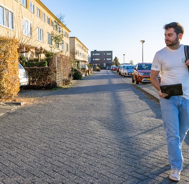Eigenaar OG Vastgoed loopt door woonstraat naar klant voor energielabel en vastgoedfotografie