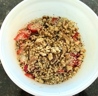 High protein oatmeal bowl topped with walnuts, hemp hearts, and strawberries.