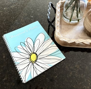 Personalized notebook on a kitchen island with a flower and small pumpkin beside it