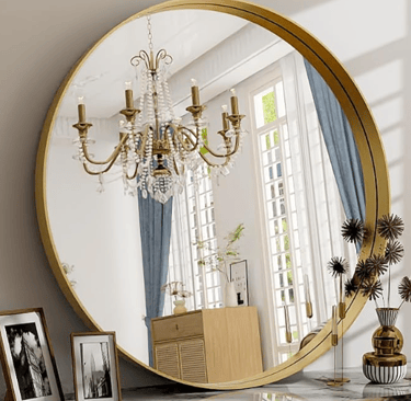 large round gold mirror reflecting gold chandalier in a room fill of large panel windows