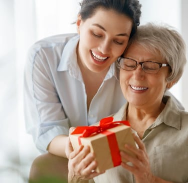Una hija dándole un regalo personalizada a su mamá por el día de la madre.