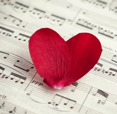 Partitura de música con un corazón en el centro representando canciones románticas.