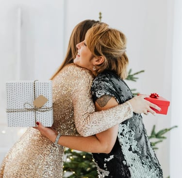 Una hija le hace un regalo personalizado a su madre y le da un abrazo cariñoso.