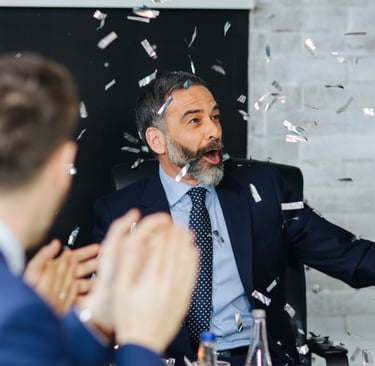 Compañero de trabajo feliz en su fiesta de despedida por jubilación escuchando una canción personalizada de Musycol.