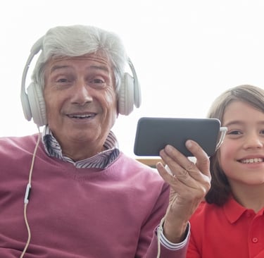 Abuelo con su nieto sonriendo y disfrutando de una canción personalizada de Musycol.