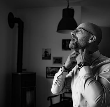 Un homme en chemise blanche remettant son col