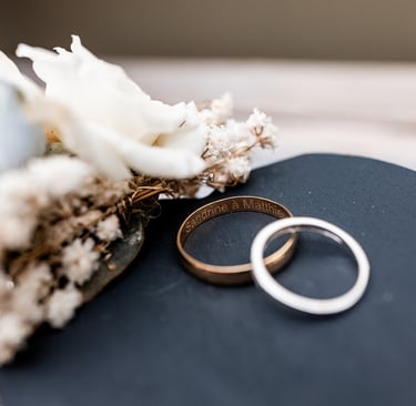 Deux alliances posées l'une sur l'autre près dune composition florale