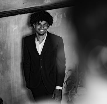 Un homme en costume noir debout souriant