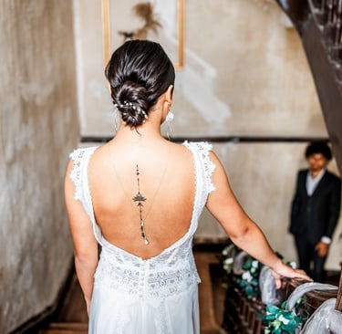 Une femme en robe de mariée dans les escaliers regardant son futur mari