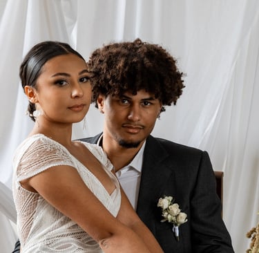 Un couple en tenue de mariés regardant la caméra