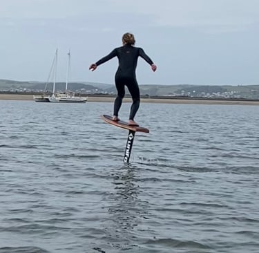 Foiler pumping across the estuary on a foil board
