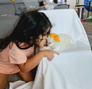 Little girl giving puppy loving kisses