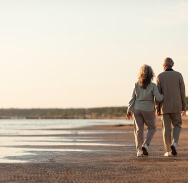 hombre y mujer jubilados andando por la playa