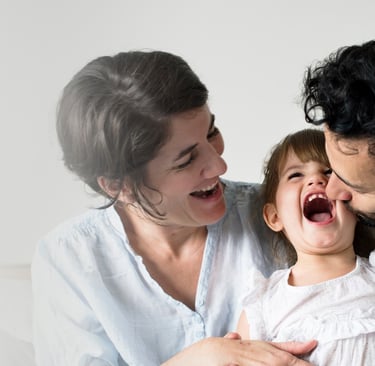 a man and woman and daughter laughing together