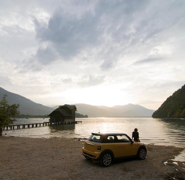 a man standing next to a car parked on a beach