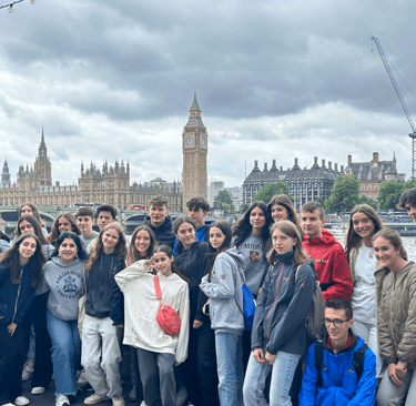 Un grupo de estudiantes en un viaje escolar a Londres posando frente al Big Ben y al Parlamento.