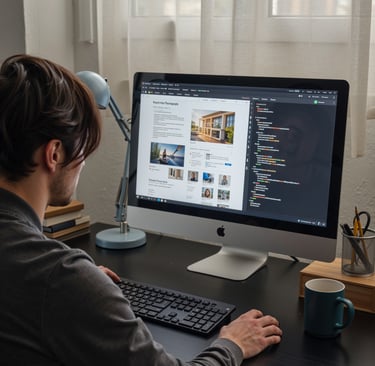 a man sitting in front of the working desk, building a web site with coding