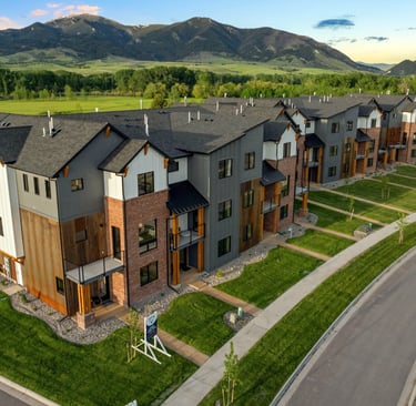 a large apartment complex with a lot of grass and a road