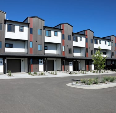 a row of apartment buildings with a parking lot