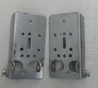 Bottom fixtures for garage door cables.