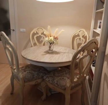 cuatro sillas y una mesa de comedor restaurada con efecto madera de color gris y blanco