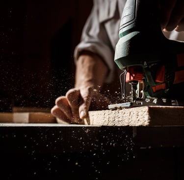 man working on a piece of wood with a jigsaw