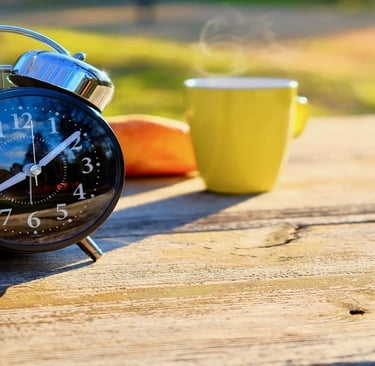Alarm clock and Tea Cup on the Table