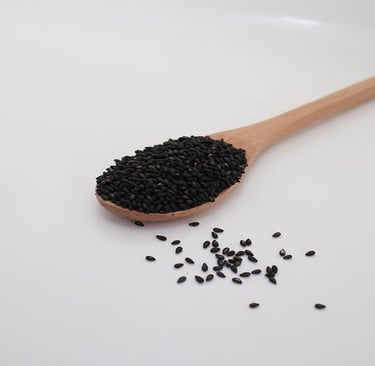 Black Sesame Seeds on a wooden spoon
