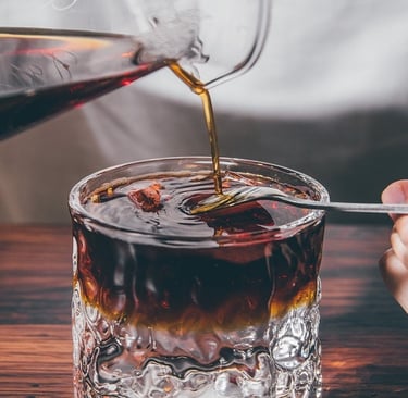 Pouring coffee in a glass cup