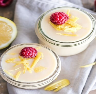 Curd in glass jar with oranges and raspberries