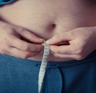 Person holding measuring tape around his stomach