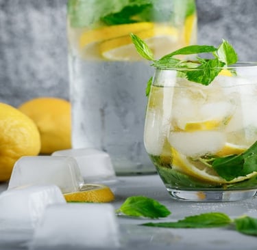 Lemonade in a glass and Lemons with ice cubes