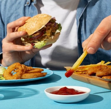 A man eating burger and fries