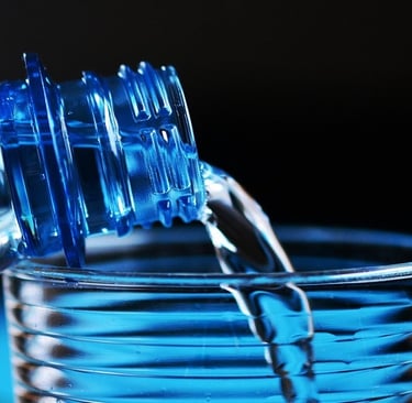 Bottle pouring water into the glass