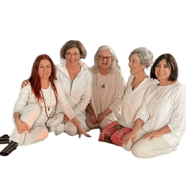 Five smiling senior women posing together in white yoga outfits during a wellness retreat.