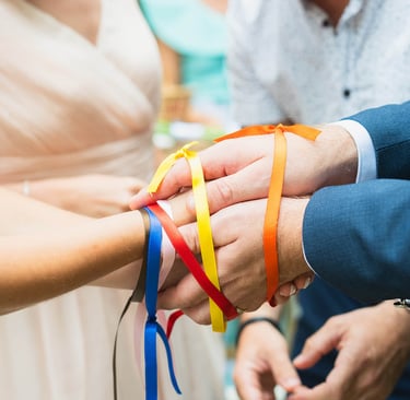 Rituel des rubans colorés lors d’un mariage, illustrant la coordination du jour J par Clair Agence