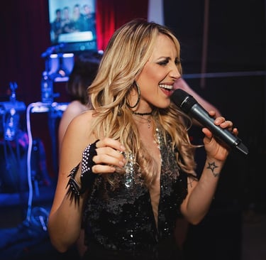 Singer Keka singing with a microphone in hand.