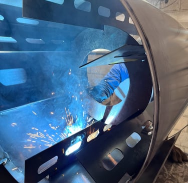 Soldador trabalhando com equipamento de solda TIG em peça de caldeiraria