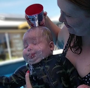 a baby is being held by a woman in a bathing suit