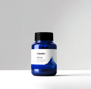 Frasco azul da marca Cobalto sobre fundo branco minimalista, com rótulo limpo e visual sofisticado,