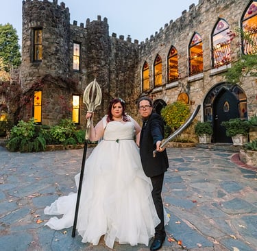 Bride and Groom stand in front of a castle holding swords. Castle is Manor Basket Range Adelaide
